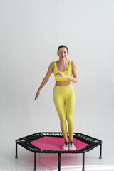 young fitness woman In sportswear jumping on sport trampoline