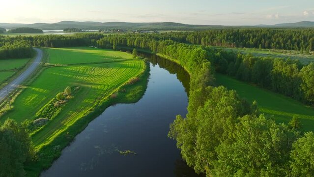 Aerial view of a river crossing the countryside at sunset in Overtornea, Sweden.
