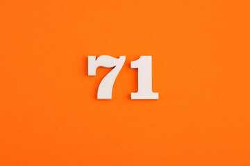 White wooden number 71 on eva rubber orange background