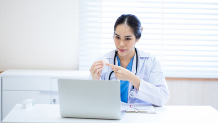 The doctor video call with a laptop to explain medicine and consult the patient at the hospital.