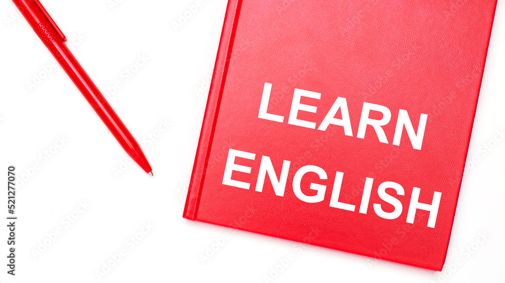 Aufkleber the text learn english is written on a red notepad near a red pen on a white table in the office. bu