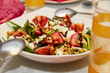 tomato salad with cheese sprinkled with pine nuts and sauce