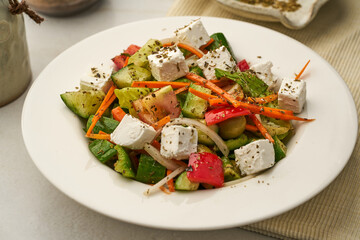 Greek Salad with cucumber, tomato, carrot served in a dish isolated on grey background side view of healthy food