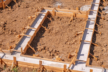 Wooden formwork for pouring concrete foundation of the house. Foundation construction.