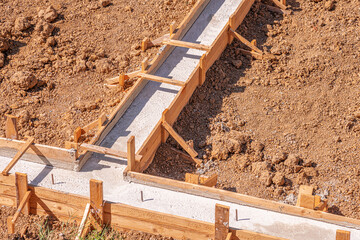 Wooden formwork for pouring concrete foundation of the house. Foundation construction.