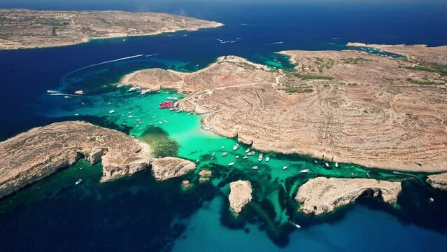 4K cinematic drone footage of the Blue Lagoon, Comino, Malta. The drone slowly descends and turns around the blue lagoon.Almost the entire island of Comino and Gozo is visible.Mediterranean Sea, Malta