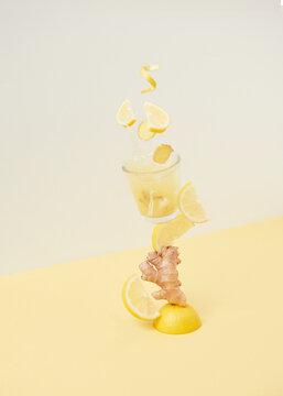 Lemons falling into glass with ginger