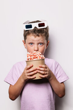 Astonished boy with 3D glasses and popcorn