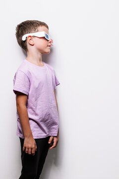 Boy in 3D glasses standing near wall