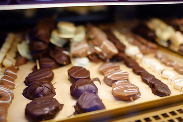 Choice of sweets on traditional street Christmas market in Krakow, Poland. Famous fruits, candy, cookies, gingerbread in chocolate glaze on skewers in bakery Xmas Eve.
