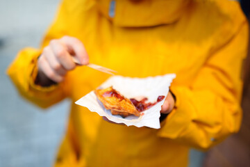 Child eating traditional Poland street food oscypek on Christmas market in Krakow. Oscypek is a...