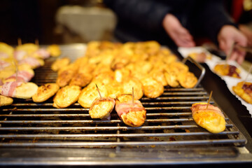 Traditional Poland street food oscypek is a grilled cheese of salted sheep milk with different ingredients as bacon or jams. Cooking of oscypek on Christmas market in Krakow.