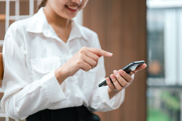 Business woman working on smartphone in office space.
