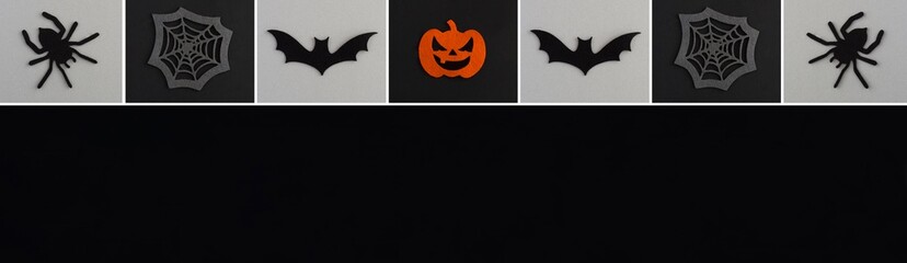 Naklejka premium Banner for Halloween. Decorative spiders, pumpkins, spider web and bat on the black and gray background. Copy space. Top view.