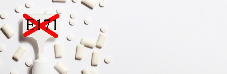 Titanium dioxide, E171, dangerous additive concept. gum, pills, toothpaste or cream and sign with E171 on white background. copy space banner
