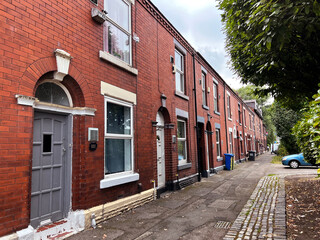 Row of Victorian red brick terrace houses, close to, Manchester Road, Denton, UK