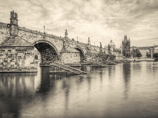 Fototapeta na wymiar View with the Charles Bridge main touristic attraction . Medieval stone arch bridge over Vltava river in Prague. Long exposure photography
