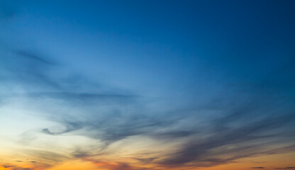 The sky at sunset or sunrise with orange clouds and a blue tint