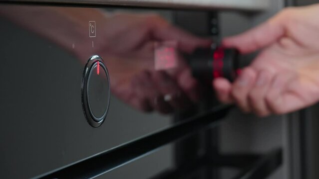 Female hand choose baking program on electric oven control panel, Woman using electric oven, Modern household appliances
