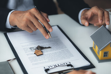 Obraz premium Rental company employee is discussing the details before the customer agrees to sign a rental contract, explaining the details and the terms and conditions of the rental. Real estate rental ideas.