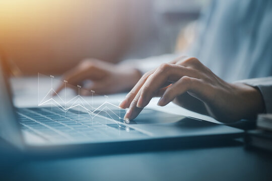 Businessman points to hologram iconcompany financial reports, graphics showing financial and numerical growth data. The concept of financial management to grow and be profitable. - Powered by Adobe