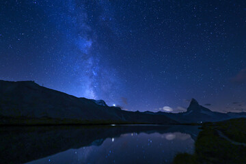 Matterhorn and the milkyway with reflection on the Stellisee lake at summer midnight, Zermatt,...