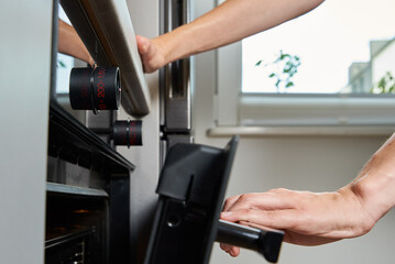 Female hand open electric oven door with handle, Woman using electric oven, Modern household appliances