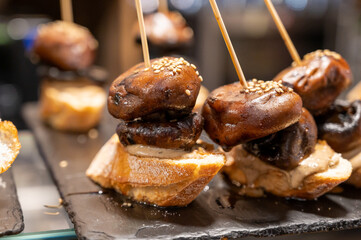 Typical snack is bars of Basque Country and Navarre, pinchos or pinxtos, small slices of bread upon which ingredient or mixture of ingredients is placed and fastened with skewers, San Sebastian, Spain