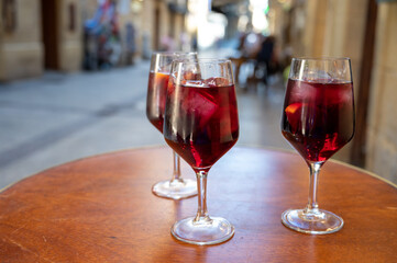 Glasses of cold sangria wine served outdoor in bar with view on old street in San Sebastian, Basque Country, Spain