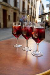 Glasses of cold sangria wine served outdoor in bar with view on old street in San Sebastian, Basque Country, Spain