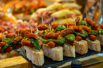 Typical snack of Basque Country and Navarre, pinchos or pinxtos, small piece of bread with different toppings, served in bar, Bilbao, Spain