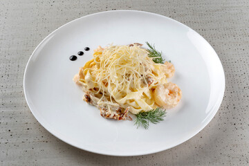 A plate of delicious shrimp alfredo with garlic and cream sauce over pasta.