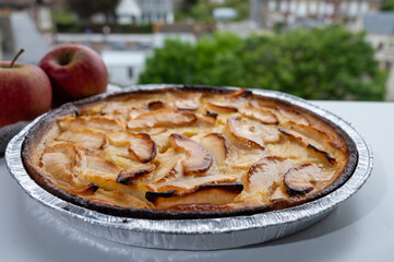 Tasty sweet French dessert, baked apple cake and view on old houses of Etretat, Normandy, France