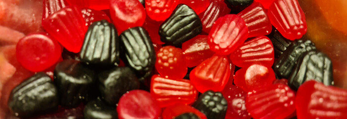 Fototapeta na wymiar Red black gelatins in form of berries closeup