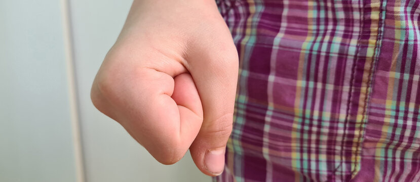 Angry emotional clenched fist of child near leg