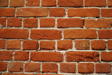 Fragment of a ceramic brick wall with white masonry mortar, white masonry seams, close-up