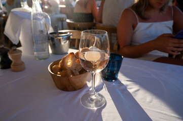 Dinner at sunset in French restaurant with cold dry rose wine in Port Grimaud, summer vacation on French Riviera, France