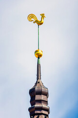 Symbol of old Riga town in Latvia - golden cockerel (rooster) topping bell tower of Riga Doms...