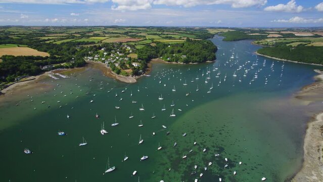 Aerial shot of Helford River in Cornwall with numerous watercraft , boats and pleasure craft on water.