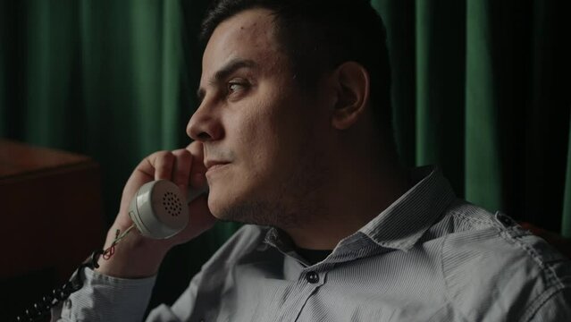 Special secret agent speaks by old phone. Spying or intelligence gathering. Espionage concept. Report information to superiors. Cold war concept.
