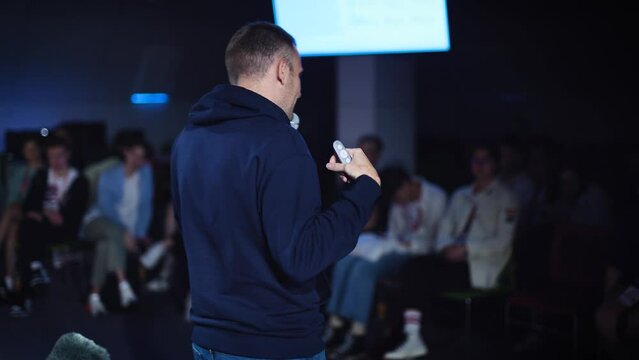 Conference in the IT industry. A young and successful male speaker talks about modern solutions to students and colleagues.