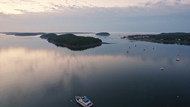 Early morning drone aerial of docked ships and boats near ocean, islands, and Acadia National Park in Bar Harbor, Maine