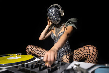 Masked female dj with turntables - obrazy, fototapety, plakaty