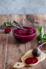 The cooking vegan homemade beetroot ice cream on a wooden table. Glass plate with beetroot ice cream. Healthy frozen vegan cold dessert