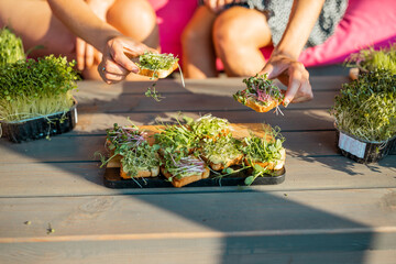 woman eating Buns with Organic micro green srpouts. Healthy food and diet concept. Vegan food.