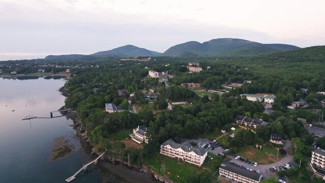 Aerial view of hotels, homes, buildings, and Acadia National Park forest and mountains on Bar Harbor, Maine peninsula 