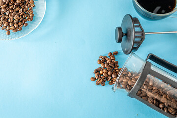 coffee beans and elements over blue background with copy space or text area
