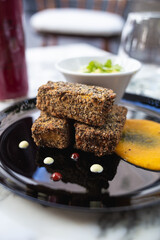 vegetable croquettes on a plate, juice, glass and sauce on the table