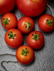 Close up of a tomato worm on a cherry tomato within a group of cherry tomatoes