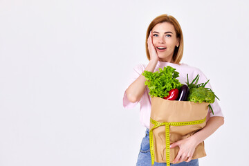 caucasian woman hold paper bag with vegetables